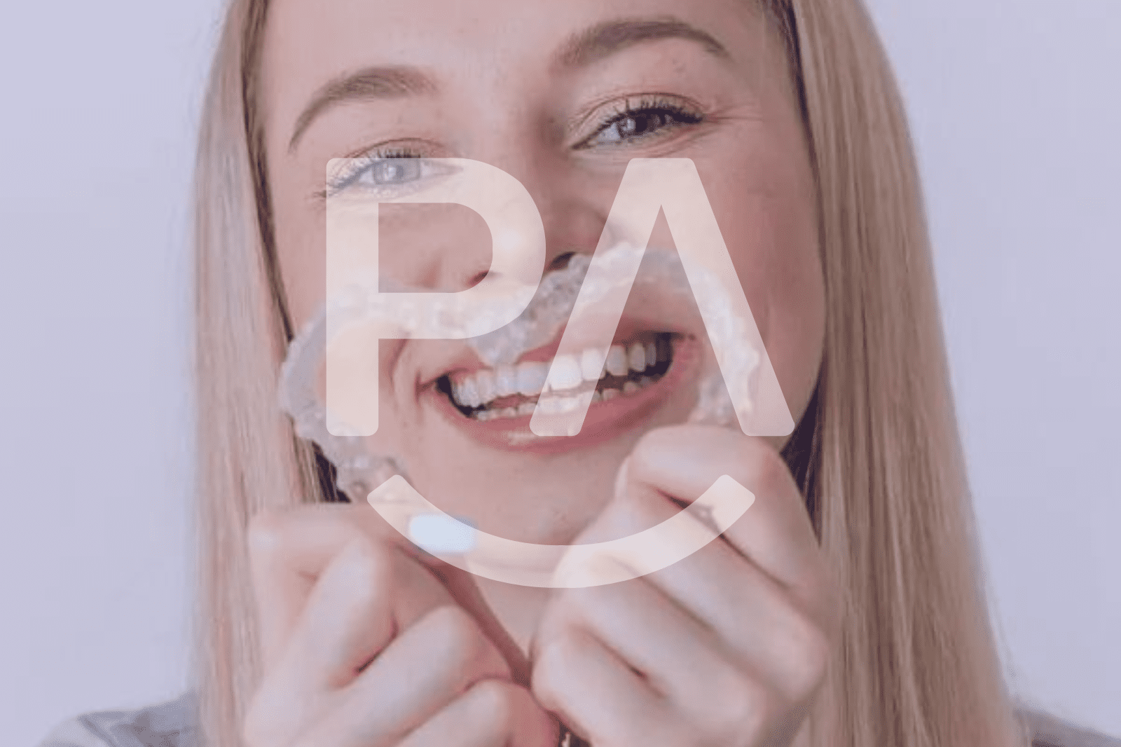 A smiling person wearing clear aligners, highlighting their nearly invisible appearance.